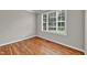 Cozy bedroom featuring hardwood floors, neutral paint, and a large window at 8140 Consella Way, Willow Springs, NC 27592