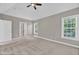 Large bedroom has neutral walls, plush carpet, a fan, and is illuminated by two bright windows at 8140 Consella Way, Willow Springs, NC 27592