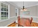 Elegant dining room featuring a wood table, decorative chandelier, and ample sunlight at 8140 Consella Way, Willow Springs, NC 27592