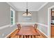 Formal dining room with wood table, chandelier, wainscoting and natural light at 8140 Consella Way, Willow Springs, NC 27592