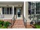 Inviting front porch with black railings, brick steps, and classic architectural details at 8140 Consella Way, Willow Springs, NC 27592
