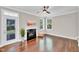 Bright living room with a fireplace, natural light, hardwood floors, and a ceiling fan at 8140 Consella Way, Willow Springs, NC 27592