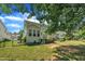 Well-maintained backyard with a sunroom and deck, complemented by green lawn, a fence, and flourishing plants at 85 Clubhouse Dr, Youngsville, NC 27596