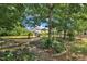 Spacious backyard featuring a hammock, mature trees, and lush landscaping, perfect for relaxation and outdoor enjoyment at 85 Clubhouse Dr, Youngsville, NC 27596