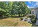 A scenic backyard featuring mature trees, a lush lawn, and a variety of plantings creates a serene retreat at 85 Clubhouse Dr, Youngsville, NC 27596