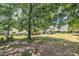 The backyard with mature trees, lawn, and a hammock, presents an inviting outdoor area for relaxation at 85 Clubhouse Dr, Youngsville, NC 27596