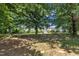 The expansive backyard with mature trees and a storage shed presents a beautiful outdoor space at 85 Clubhouse Dr, Youngsville, NC 27596