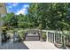 An outdoor deck with a built-in bench and potted plants provides a charming space to relax and enjoy nature at 85 Clubhouse Dr, Youngsville, NC 27596