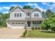 Charming two-story home featuring a manicured lawn, two car garage, and inviting front porch at 85 Clubhouse Dr, Youngsville, NC 27596