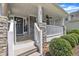 Inviting front porch with stone pillars, white railing, and a ceiling fan for outdoor relaxation at 85 Clubhouse Dr, Youngsville, NC 27596