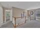 Upper hallway boasts neutral carpet and leads to bedrooms with natural light and open doorways at 85 Clubhouse Dr, Youngsville, NC 27596