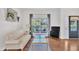 Bright living room featuring hardwood floors, stylish sofa, and large windows with backyard view at 85 Clubhouse Dr, Youngsville, NC 27596