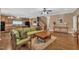 Inviting living room featuring hardwood floors, a stylish green sofa, and seamlessly connected to a kitchen area at 85 Clubhouse Dr, Youngsville, NC 27596