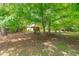 Backyard with playset nestled beneath mature trees, perfect for Gathering fun at 8536 Wolverton Fields Dr, Wake Forest, NC 27587