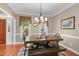 Dining room showcasing a wooden table, bench seating, chandelier, and natural light from surrounding windows at 8536 Wolverton Fields Dr, Wake Forest, NC 27587