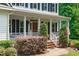 Inviting front porch with white columns, charming decor, and a well-maintained landscape at 8536 Wolverton Fields Dr, Wake Forest, NC 27587