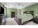 Main bedroom featuring green walls, carpet flooring, a tray ceiling, and ample space at 8536 Wolverton Fields Dr, Wake Forest, NC 27587
