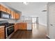 Well-lit kitchen features wooden cabinetry, modern appliances, and hardwood floors leading to a spacious living area at 8630 Neuse Landing # 105, Raleigh, NC 27616