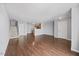 Open concept living space with hardwood floors, showcasing seamless flow to the kitchen and staircase at 8630 Neuse Landing # 105, Raleigh, NC 27616