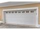 White garage door featuring decorative windows and exterior house number 104 at 9211 Calabria Dr # 104, Raleigh, NC 27617