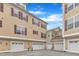 Row of townhome garages with tan siding, white doors, and visible unit numbers at 9211 Calabria Dr # 104, Raleigh, NC 27617