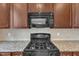 Close-up view of the range and microwave with countertops and cabinetry at 9211 Calabria Dr # 104, Raleigh, NC 27617