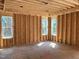 Bedroom framing with exposed wood beams, interior walls, and multiple window openings at 93 Bur Oak Ct, Pittsboro, NC 27312