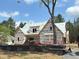 New construction home featuring wood framing, protective wraps, and a modern design with lush greenery at 93 Bur Oak Ct, Pittsboro, NC 27312