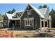 New construction home featuring gray vertical siding, white trim, and ladders for painting, with a builder on the ladder at 93 Bur Oak Ct, Pittsboro, NC 27312