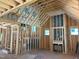 Living room framing of a new construction home featuring a fireplace, window openings, and exposed wood beams at 93 Bur Oak Ct, Pittsboro, NC 27312