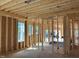 Unfinished new construction room featuring exposed framing, studs, and natural light from multiple windows at 93 Bur Oak Ct, Pittsboro, NC 27312