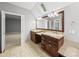 Bright bathroom featuring double vanity, granite counters, neutral tile, and skylight at 1007 Surry Dale Ct, Apex, NC 27502