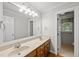 Bright bathroom featuring double vanity, granite counters, neutral tile, and large mirror at 1007 Surry Dale Ct, Apex, NC 27502