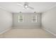 Neutral bedroom features beige carpet, two windows, and a ceiling fan at 1007 Surry Dale Ct, Apex, NC 27502