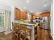 Eat-in kitchen with wood cabinets, granite counters, stainless appliances, and bar stool seating at 1007 Surry Dale Ct, Apex, NC 27502