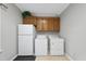 Functional laundry room featuring overhead cabinets, washer, and dryer for efficient chore management at 1007 Surry Dale Ct, Apex, NC 27502