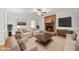Comfortable living room featuring a brick fireplace, fan, and neutral-toned furniture at 1007 Surry Dale Ct, Apex, NC 27502