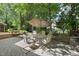Outdoor patio with seating and an umbrella, perfect for entertaining or relaxing in a tranquil backyard setting at 1007 Surry Dale Ct, Apex, NC 27502