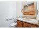 Bathroom featuring single sink vanity, a mirror, and a toilet with grab bar at 102 Pine St, Dunn, NC 28334