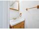 Modest bathroom features a white sink, wooden cabinets, and a vintage vanity mirror at 102 Pine St, Dunn, NC 28334
