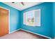 Bright bedroom featuring blue walls, a window with white shutters, and a ceiling fan at 102 Pine St, Dunn, NC 28334