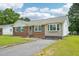 Traditional brick house with green shutters, bay window, and a paved driveway at 102 Pine St, Dunn, NC 28334
