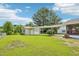 View of detached garage, carport, and lush green yard with an established tree at 102 Pine St, Dunn, NC 28334
