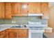 This kitchen features wood cabinetry, mosaic backsplash, and standard appliances at 102 Pine St, Dunn, NC 28334