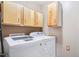 Laundry area showcasing a modern washer and dryer with upper storage cabinets at 102 Pine St, Dunn, NC 28334