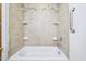 Close-up of a tiled shower and tub with built in shelves at 102 Pine St, Dunn, NC 28334