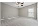 Spacious carpeted bedroom with a ceiling fan and natural light from the window at 105 Bagley Ln, Dunn, NC 28334