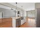Spacious kitchen island with stainless steel sink, white cabinets, and views of the fireplace at 105 Bagley Ln, Dunn, NC 28334