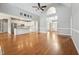 Bright living room with open kitchen, hardwood floors, ceiling fan, and large windows at 105 Bagley Ln, Dunn, NC 28334