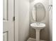 Cozy powder room featuring pedestal sink, decorative mirror, and neutral paint at 105 Bagley Ln, Dunn, NC 28334